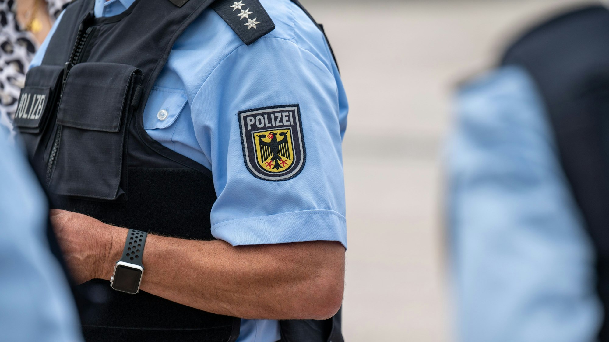 Ein Bundespolizist ist im Einsatz und spricht mit Menschen.