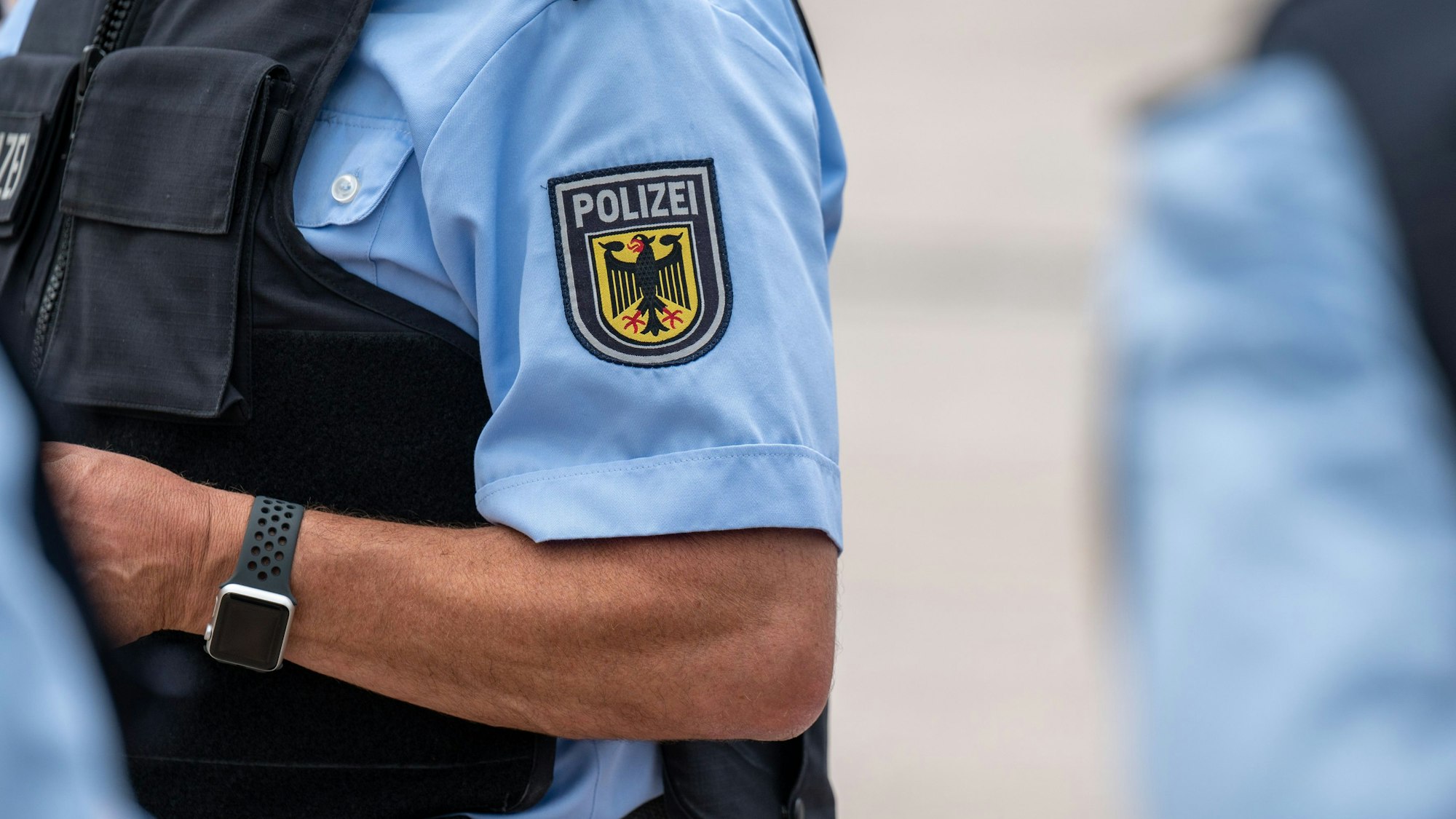 Zu sehen ist ein Bundespolizist in Uniform. Das Emblem der Bundespolizei trägt das Bild des Bundesadlers.