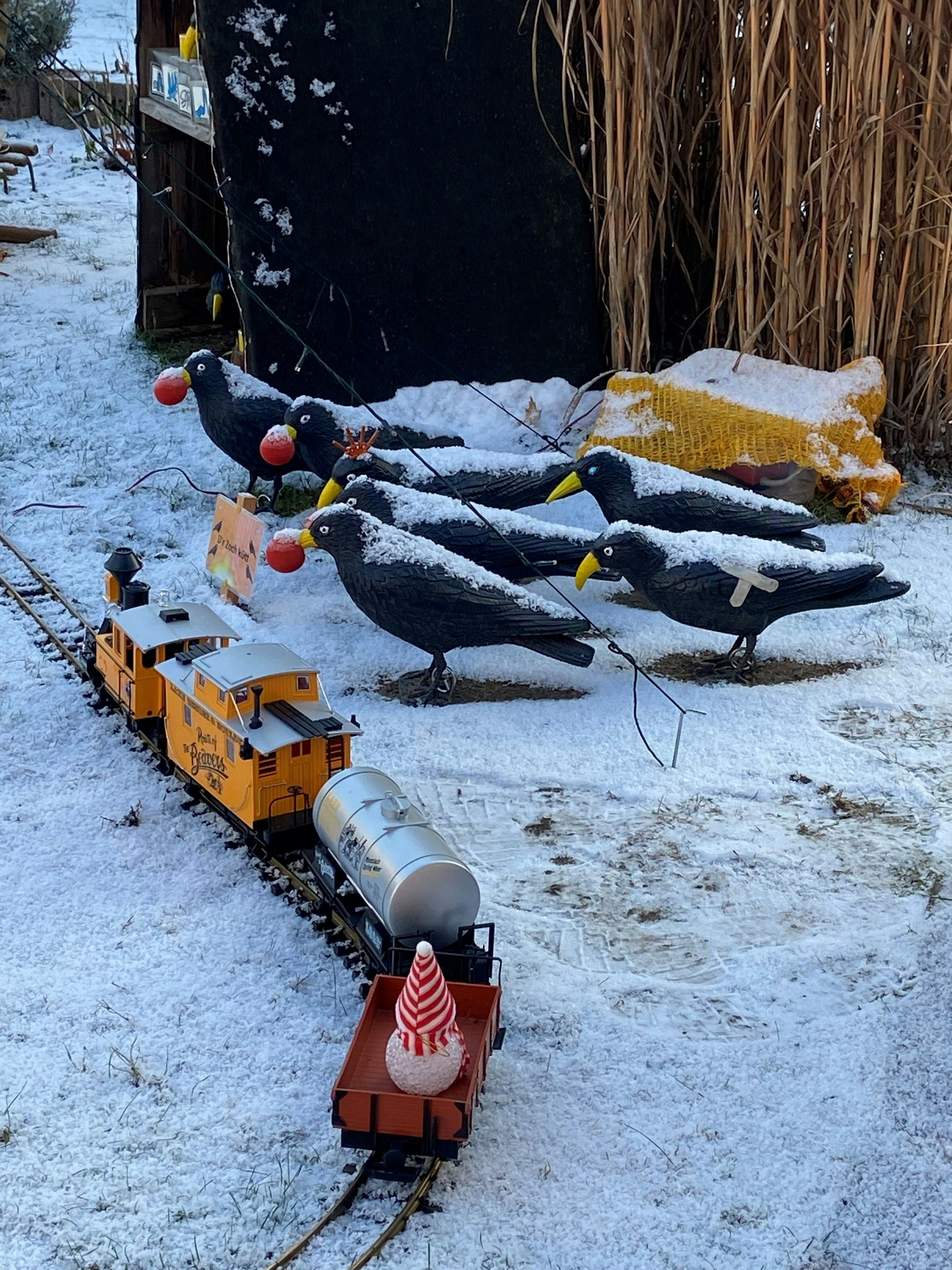 Eine Schar von Raben und eine Modelleisenbahn im Schnee stellen eine weitere Szene von Johannes Offermann dar.