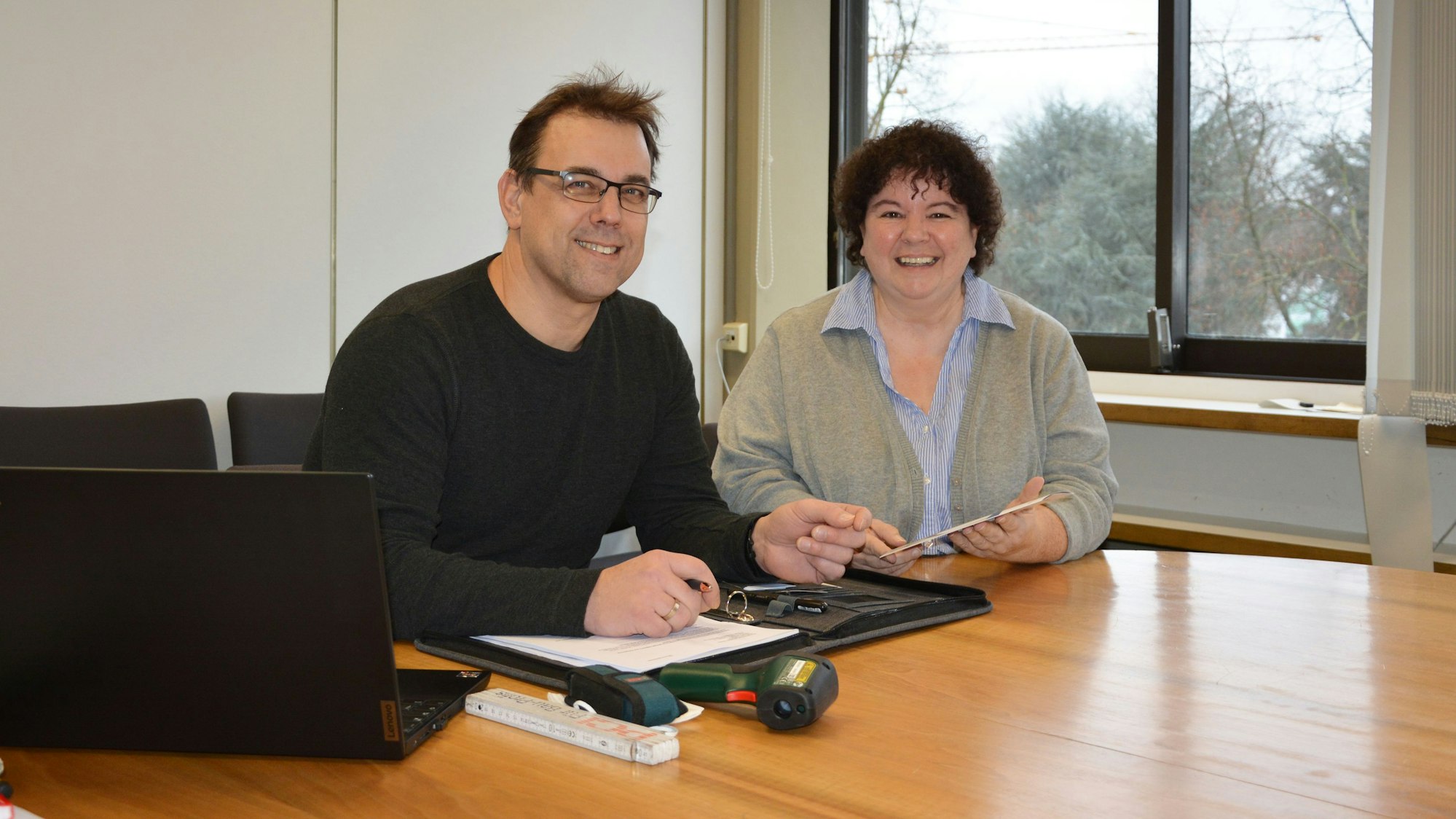 Tobias Feld und Monika Meves sitzen an einem Tisch mit Laptop und Messgeräten.