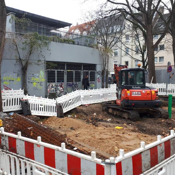 Die Baustelle auf dem Wilhelmsplatz mit abgesperrter Zone und Bagger.