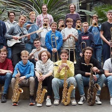 Jugendliche posieren mit ihren Instrumenten.