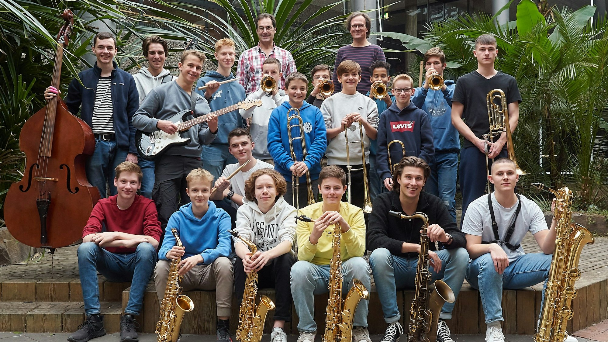 Jugendliche posieren mit ihren Instrumenten.