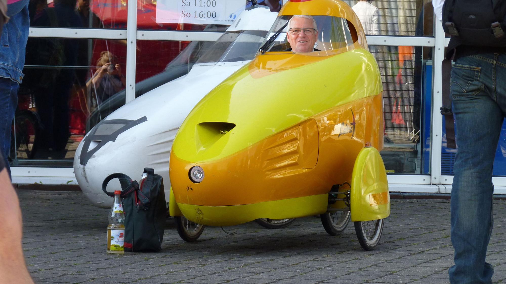 Das Foto zeigt als Fotomontage den Kürtener Bürgermeister Willi Heider, der in einem Kabinenroller sitzt.
