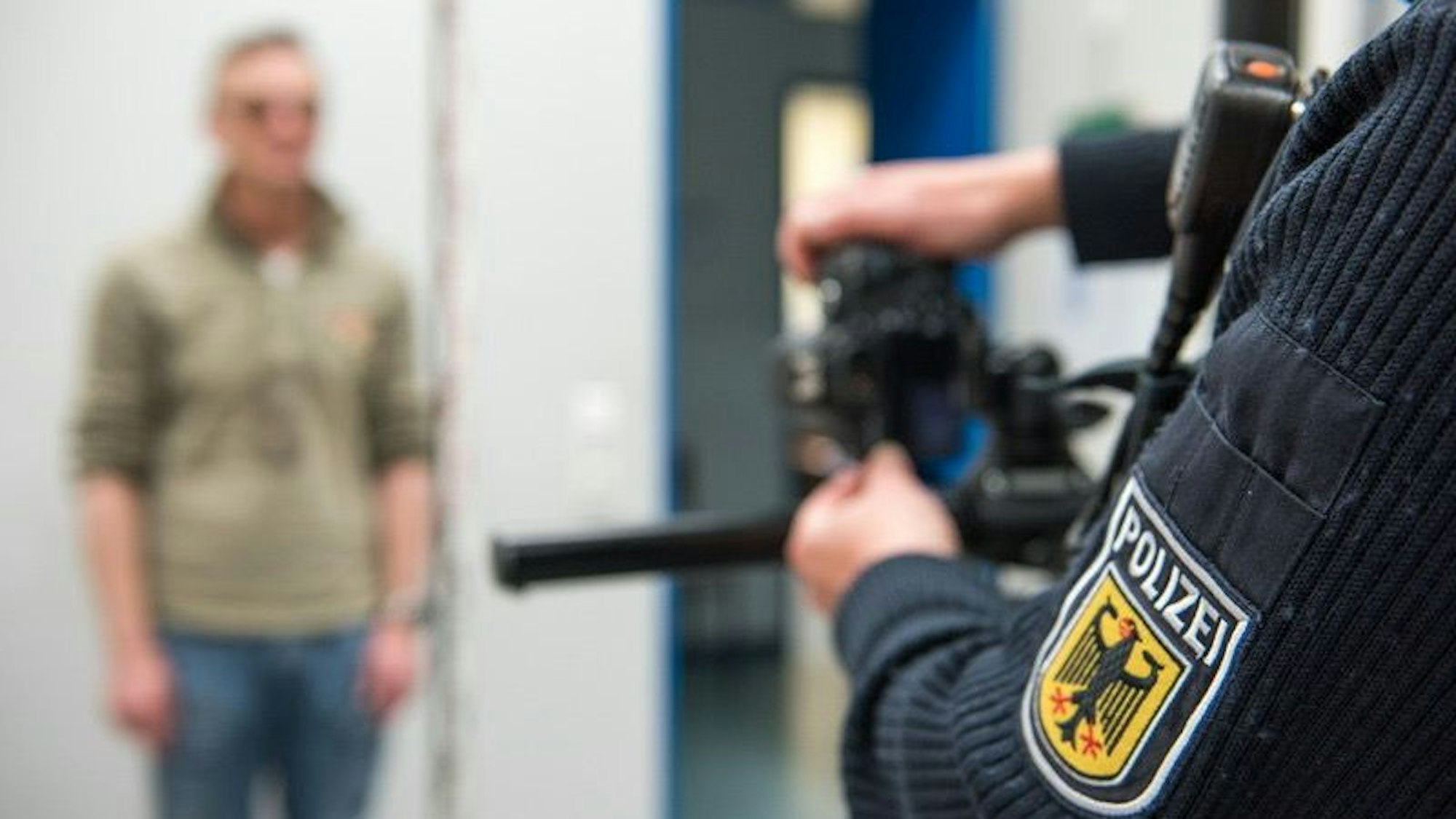 Ein Beamter der Bundespolizei macht Fotos von einem Mann auf der Dienststelle.