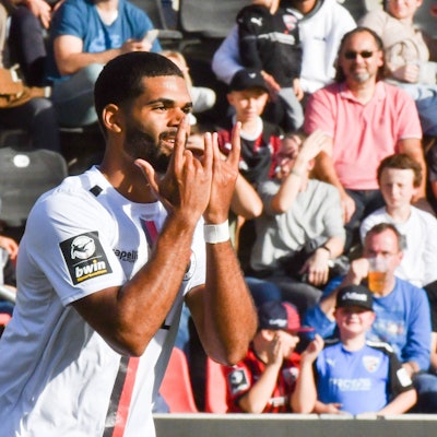 Ein Fußballspieler jubelt nach einem seiner Tore mit gespreizten Fingern.