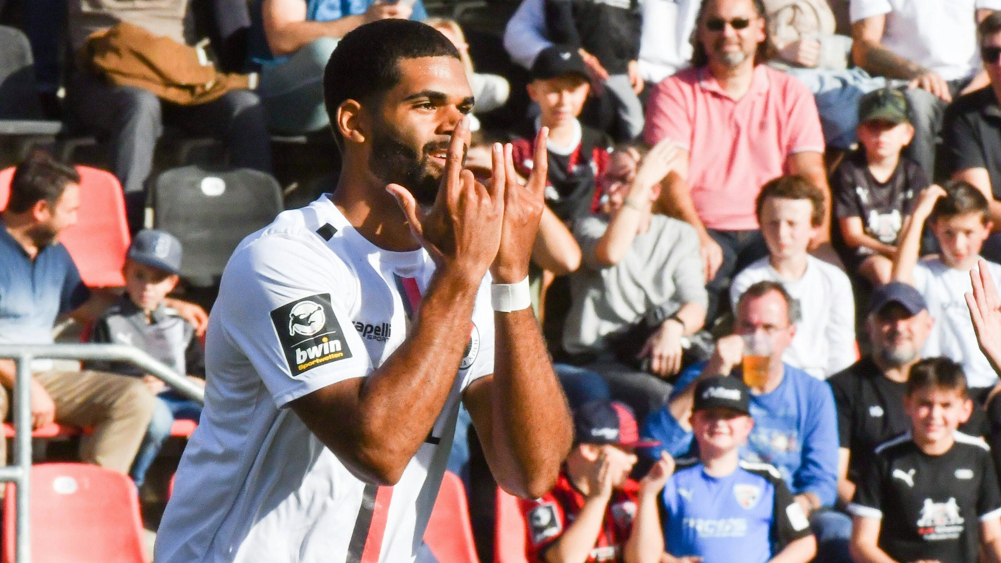 Ein Fußballspieler jubelt nach einem seiner Tore mit gespreizten Fingern.