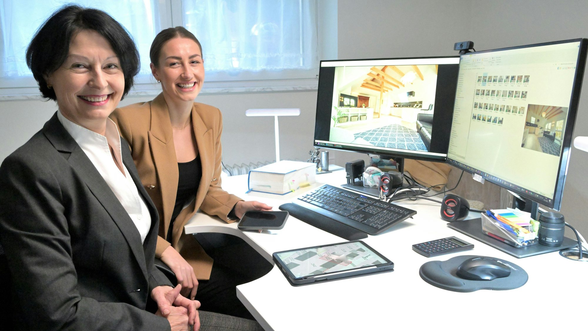 Gabriele Kreileder-Heitz und Blanca Heitz sitzen vor zwei Computerbildschirmen.