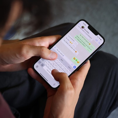 Zwei Hände tippen eine Nachricht in ein Smartphone.