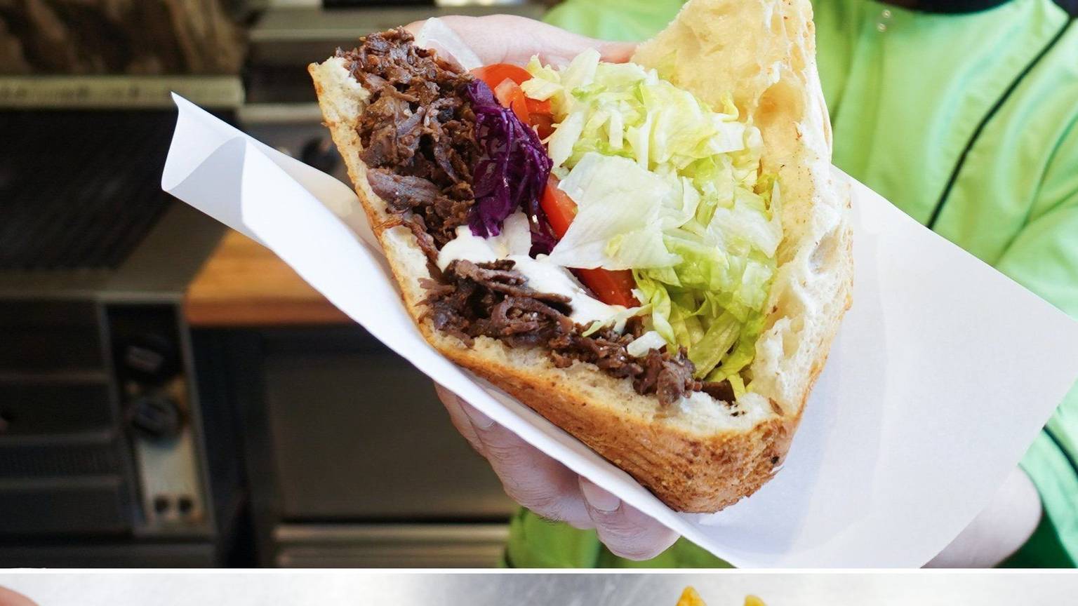 Ein Mann hält einen Döner in seinen Händen