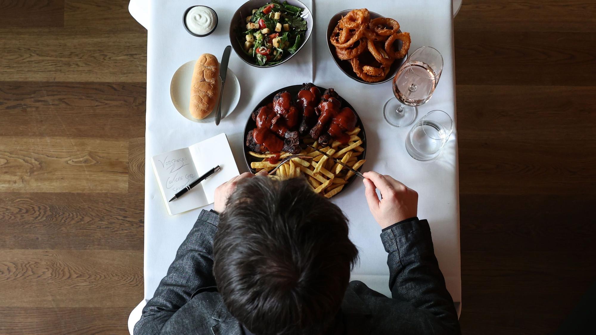 Carsten Henn vor einem Essen an einem Tisch.