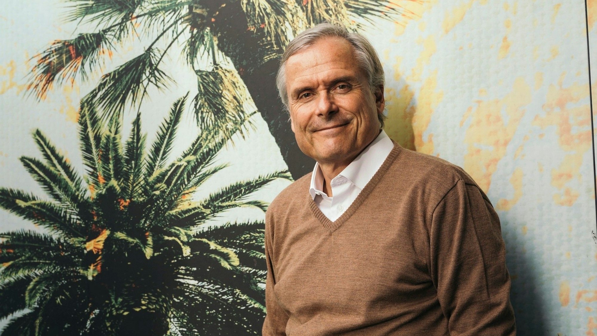 Axel Hacke vor einer Wand mit Palmenmotiv
