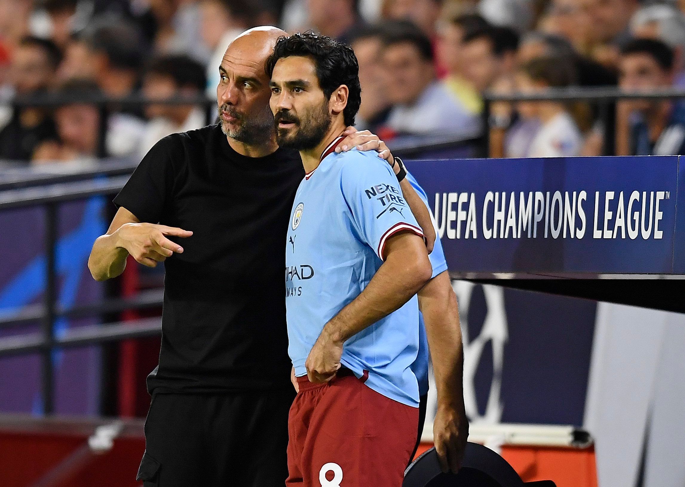 Ilkay Gündogan steht mit Manchester Citys Cheftrainer Pep Guardiola an der Seitenlinie während eines Spiels.