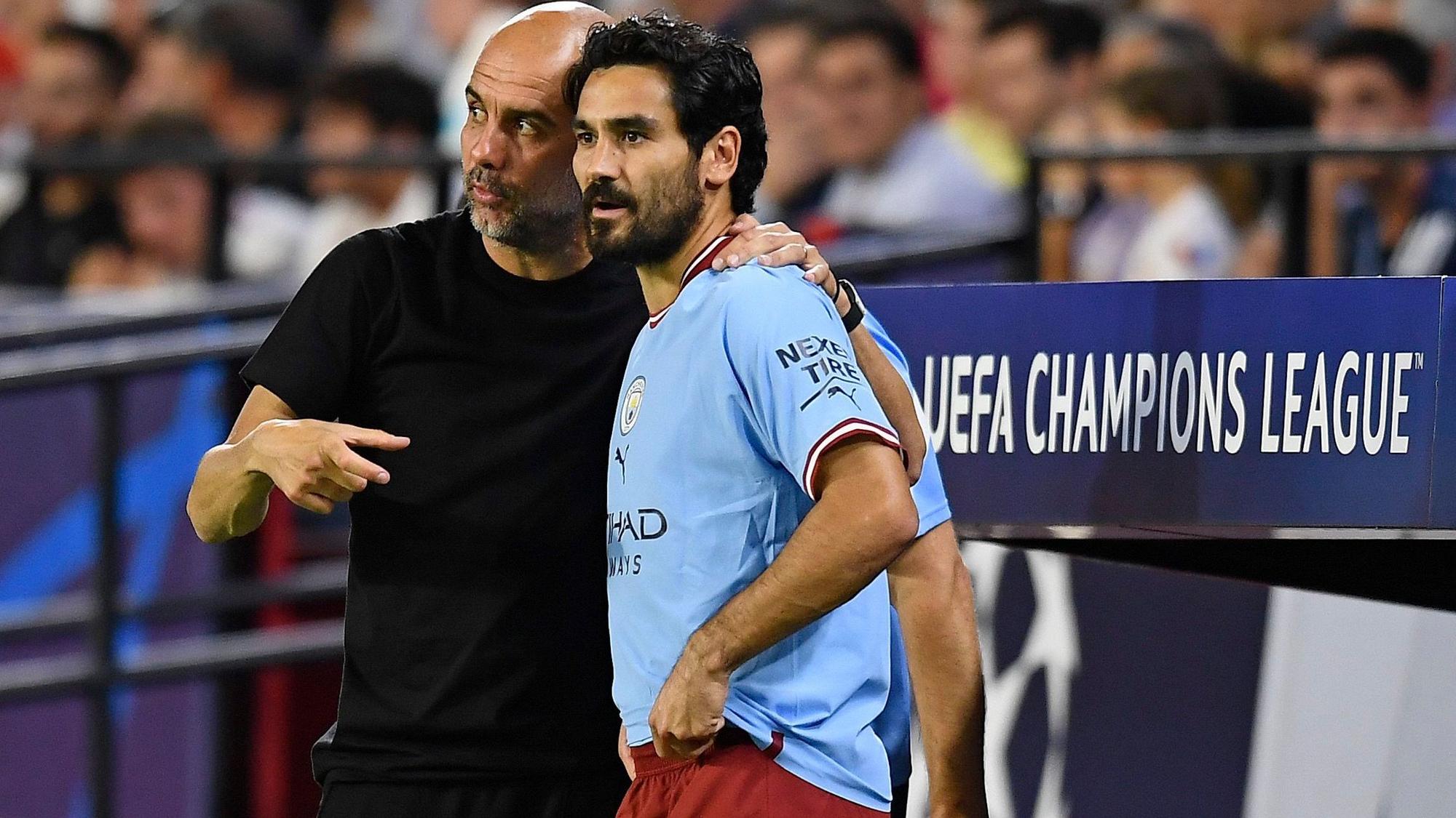 Ilkay Gündogan steht mit Manchester Citys Cheftrainer Pep Guardiola an der Seitenlinie während eines Spiels.
