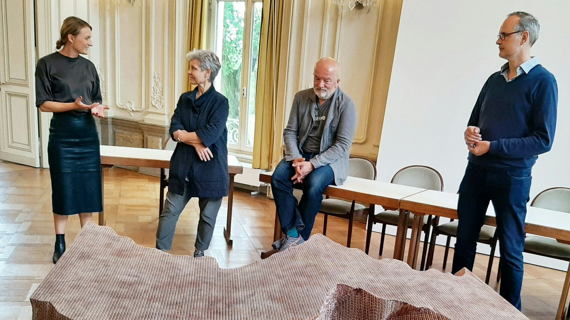 Kuratorin Thekla Zell, Künstlerin Andrea Wolfensberger, Museumsdirektor Jörg van den Berg, Kurator Fritz Emslander (v.r.) vor der von Wolfensberger gefertigten Tisch-Skulptur im Spiegelsaal von Schloss Mosbroich .
