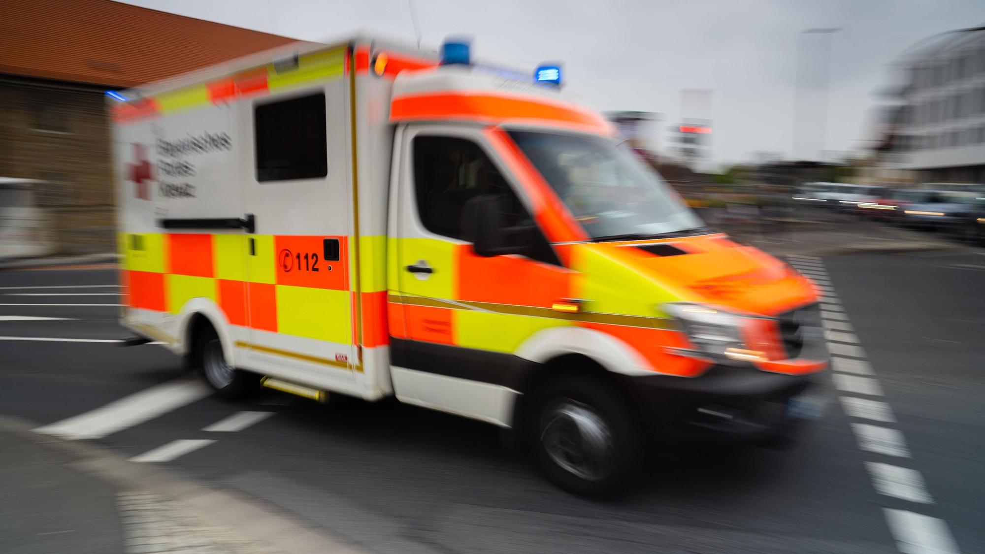 Ein Rettungswagen fährt mit Blaulicht über eine Kreuzung.