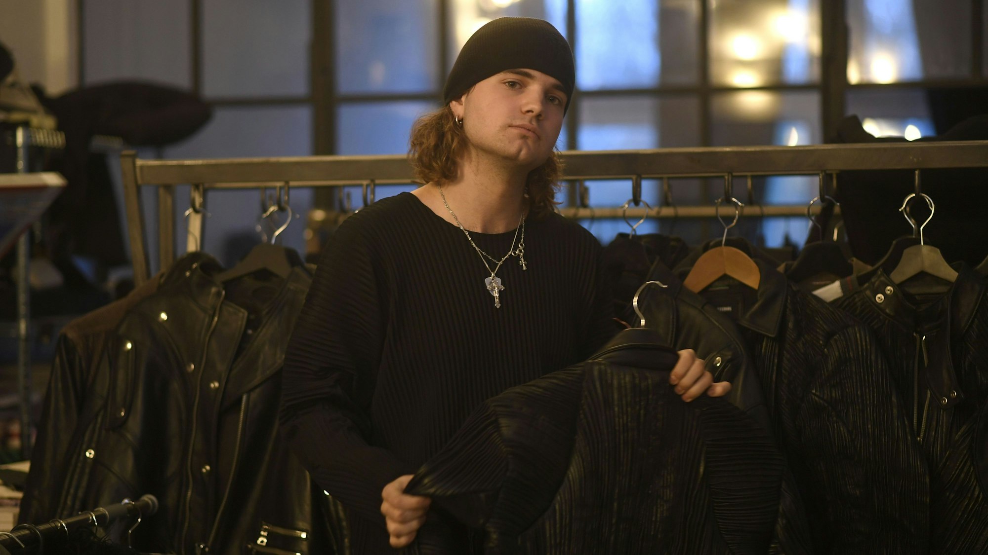 Luis Dobbelgarten trägt eine schwarze Mütze und hält eine Lederjacke in der Hand.