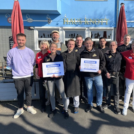 Das Team von Haus Knott und dem Brauhaus Stüsser überreichen symbolisch Schecks an Till Cremerius (l.) und Ralf Werheid (4.v.l.) für das Projekt "Fitte Finken".