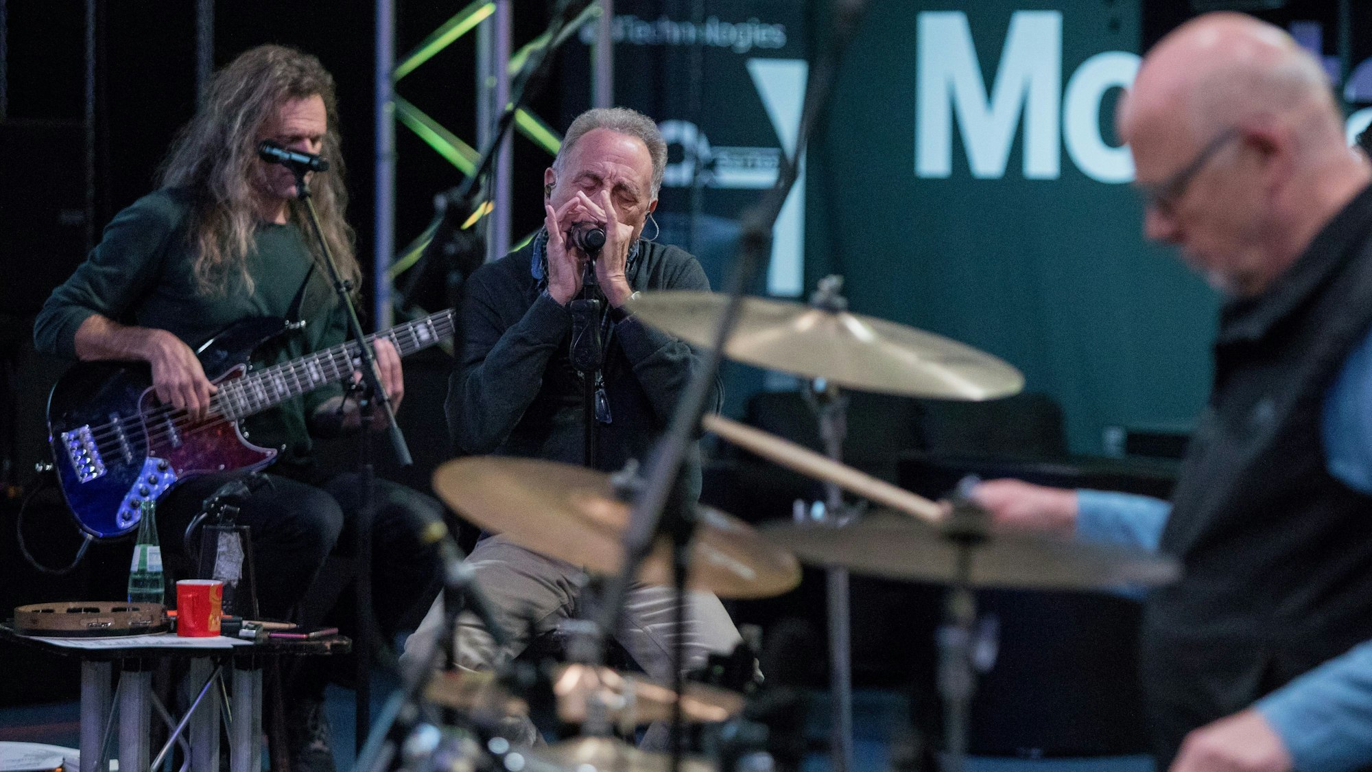 „Erry“ Stoklosa spielt an der Mundharmonika „In unserem Veedel“, er sitzt hinter dem Schlagzeug im Probenraum.