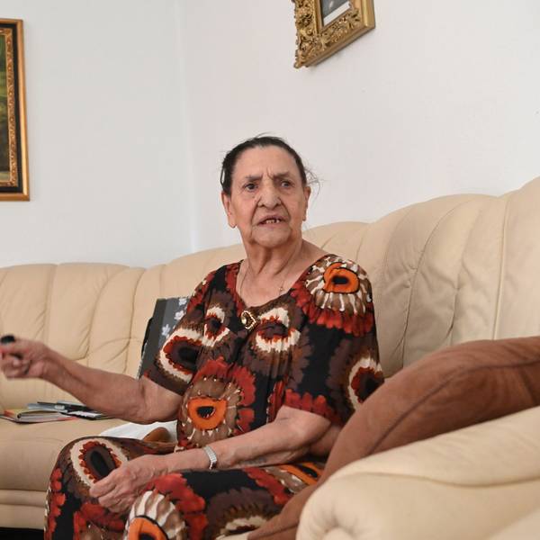 Philomena Franz sitzt auf ihrem Sofa und gestikuliert.