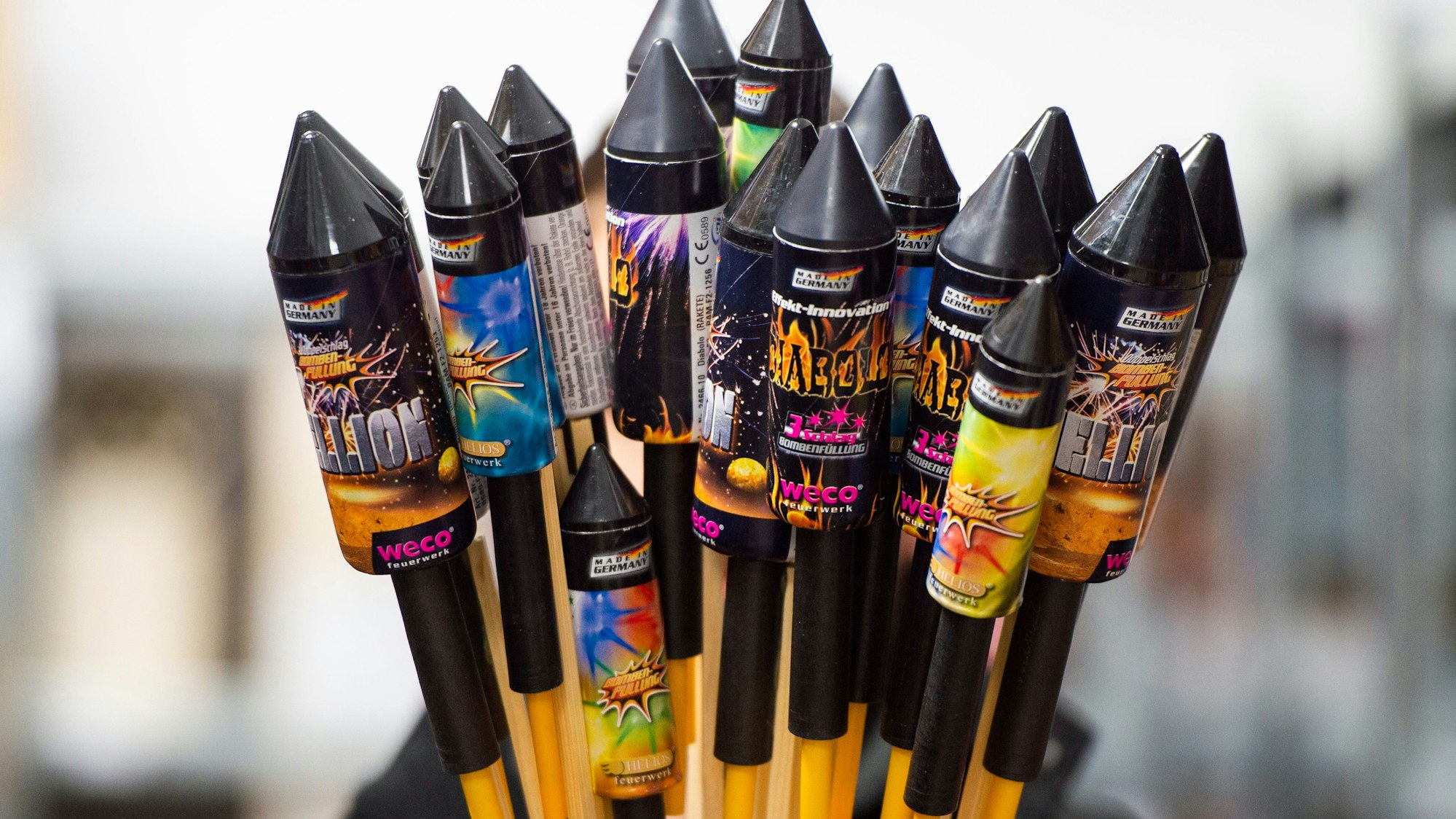 Jemand hält in einem Lagerraum Silvesterraketen.