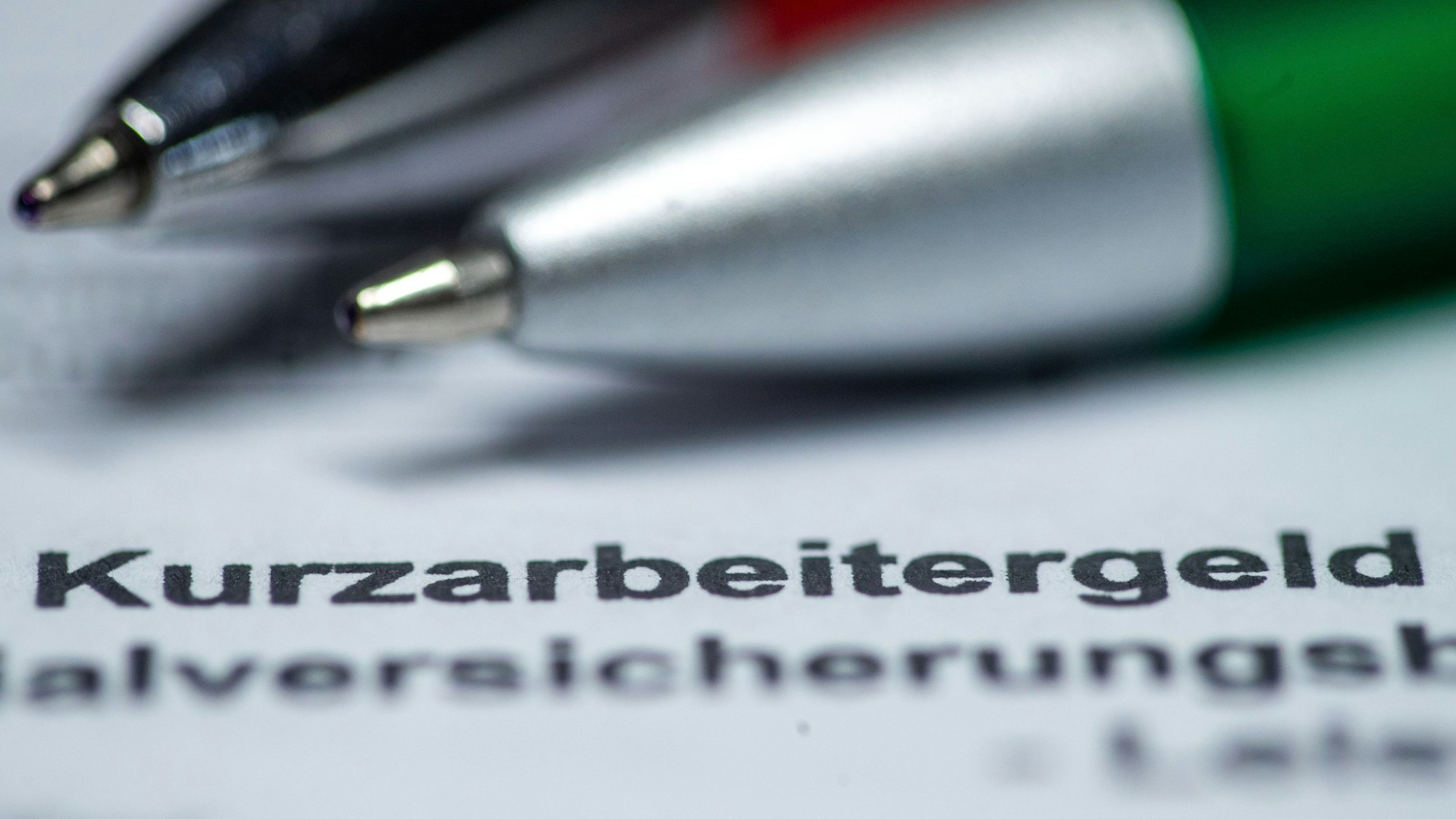 ARCHIV - 30.03.2020, Mecklenburg-Vorpommern, Schwerin: ILLUSTRATION - Zwei Kugelschreiber liegen auf einem Antragsformular für Kurzarbeitergeld.(zu dpa «Minister Heil: Vereinfachter Zugang zur Kurzarbeit bis Ende Juni 2023») Foto: Jens Büttner/dpa-Zentralbild/dpa +++ dpa-Bildfunk +++