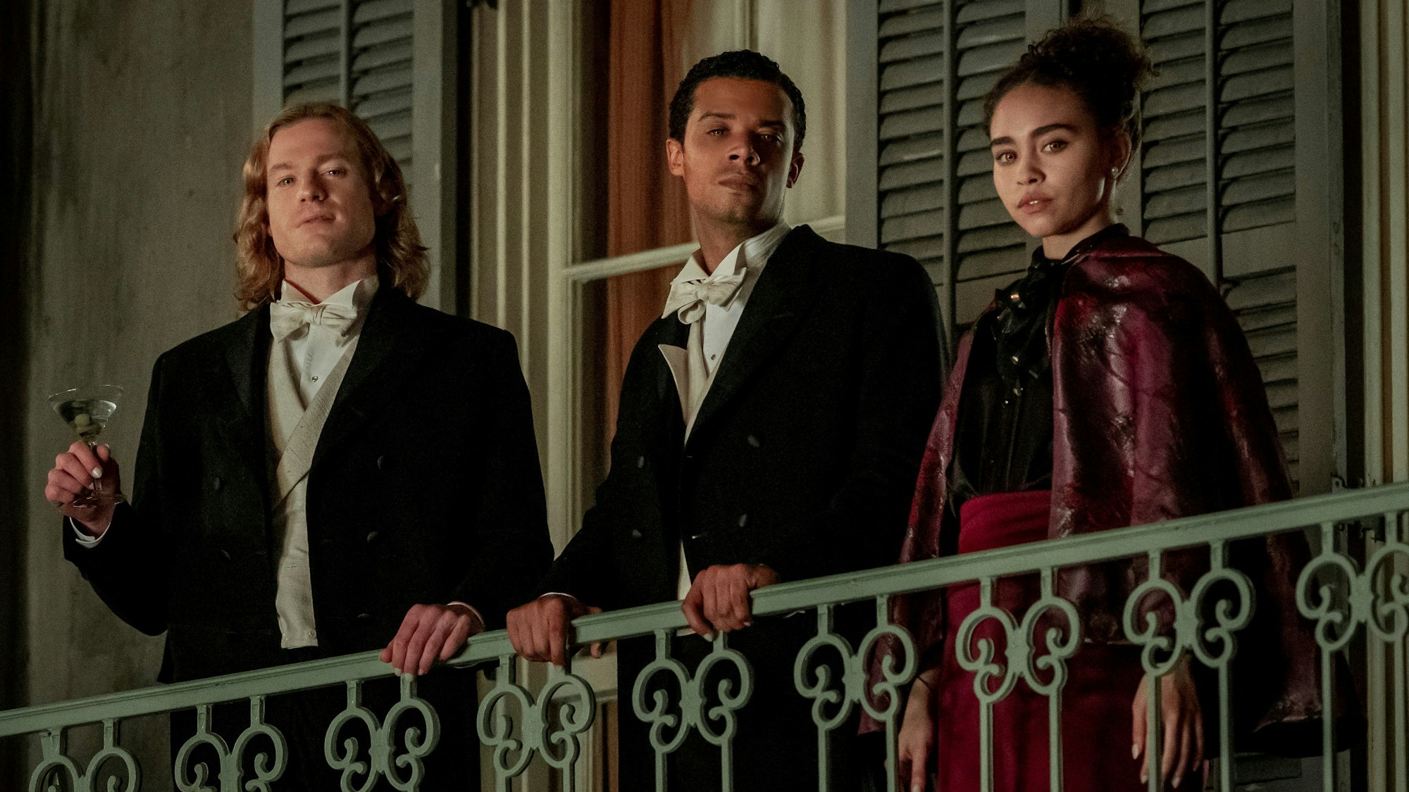 Sam Reid als Lestat De Lioncourt, Jacob Anderson als Louis De Point Du Lac und Bailey Bass als Claudia  stehen auf einem Balkon.