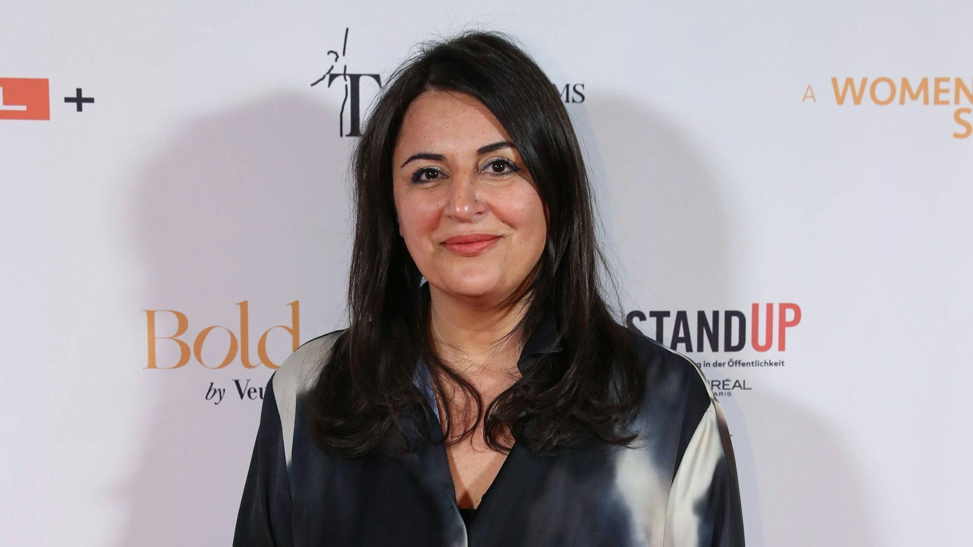 Düzen Tekkal schaut lächelnd in die Kamera.