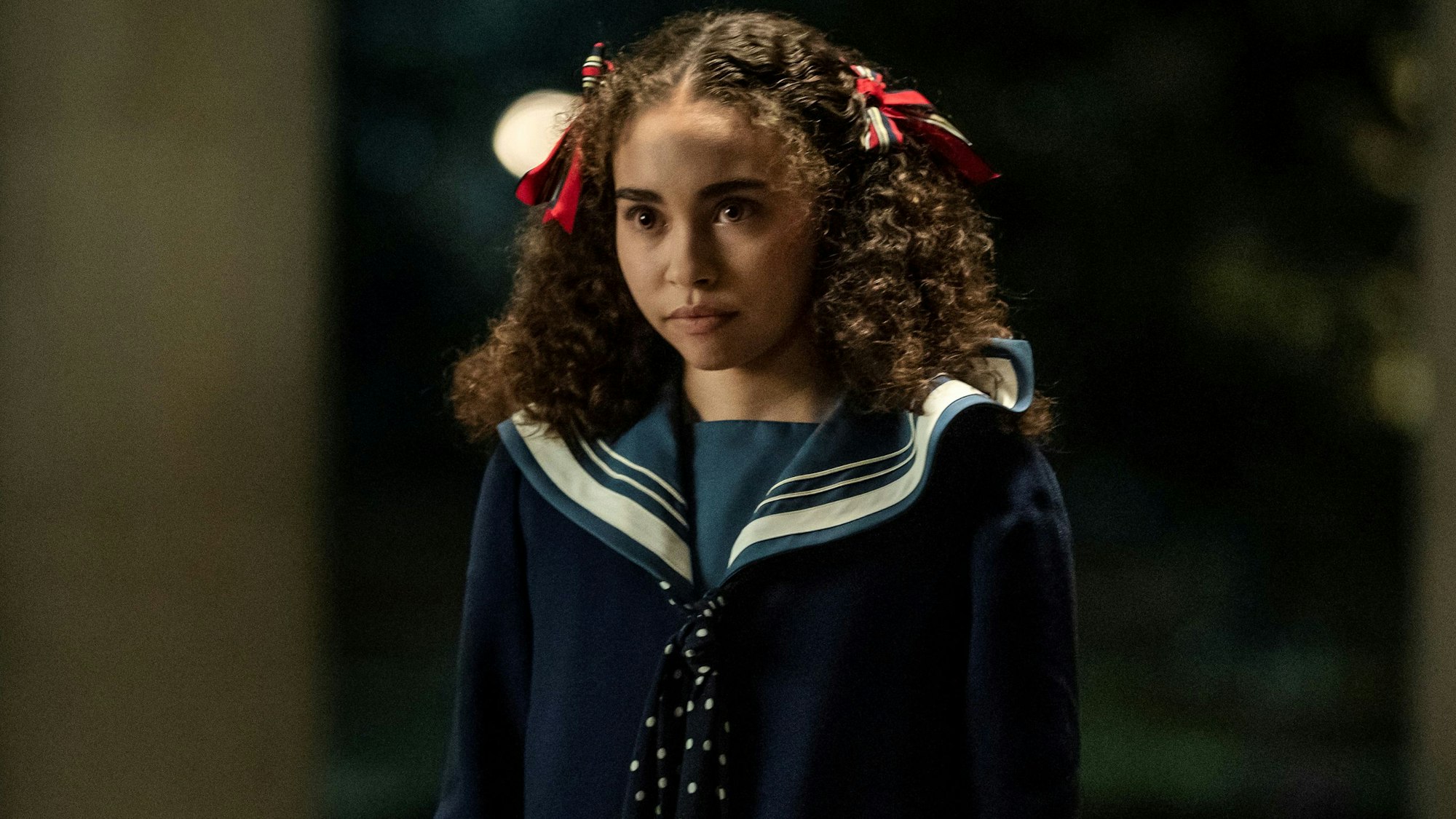 Bailey Bass als Claudia in einem kindlichen Kostüm.