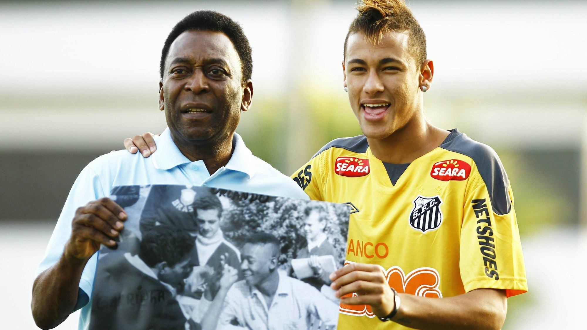 Pele zeigt Neymar FC Santos ein Foto aus seiner aktiven Zeit auf dem er eine ähnliche Frisur trägt.