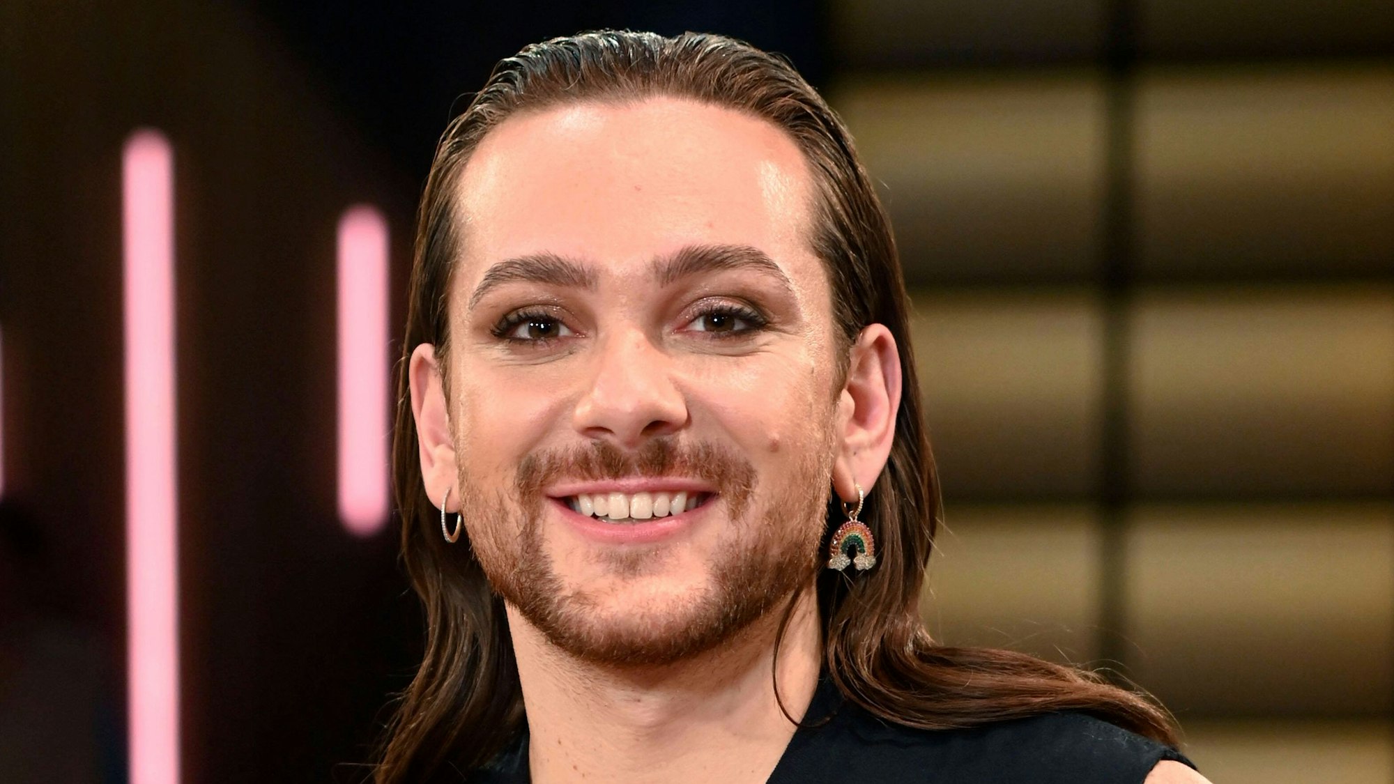 Der Moderator Riccardo Simonetti lächelt in die Kamera.