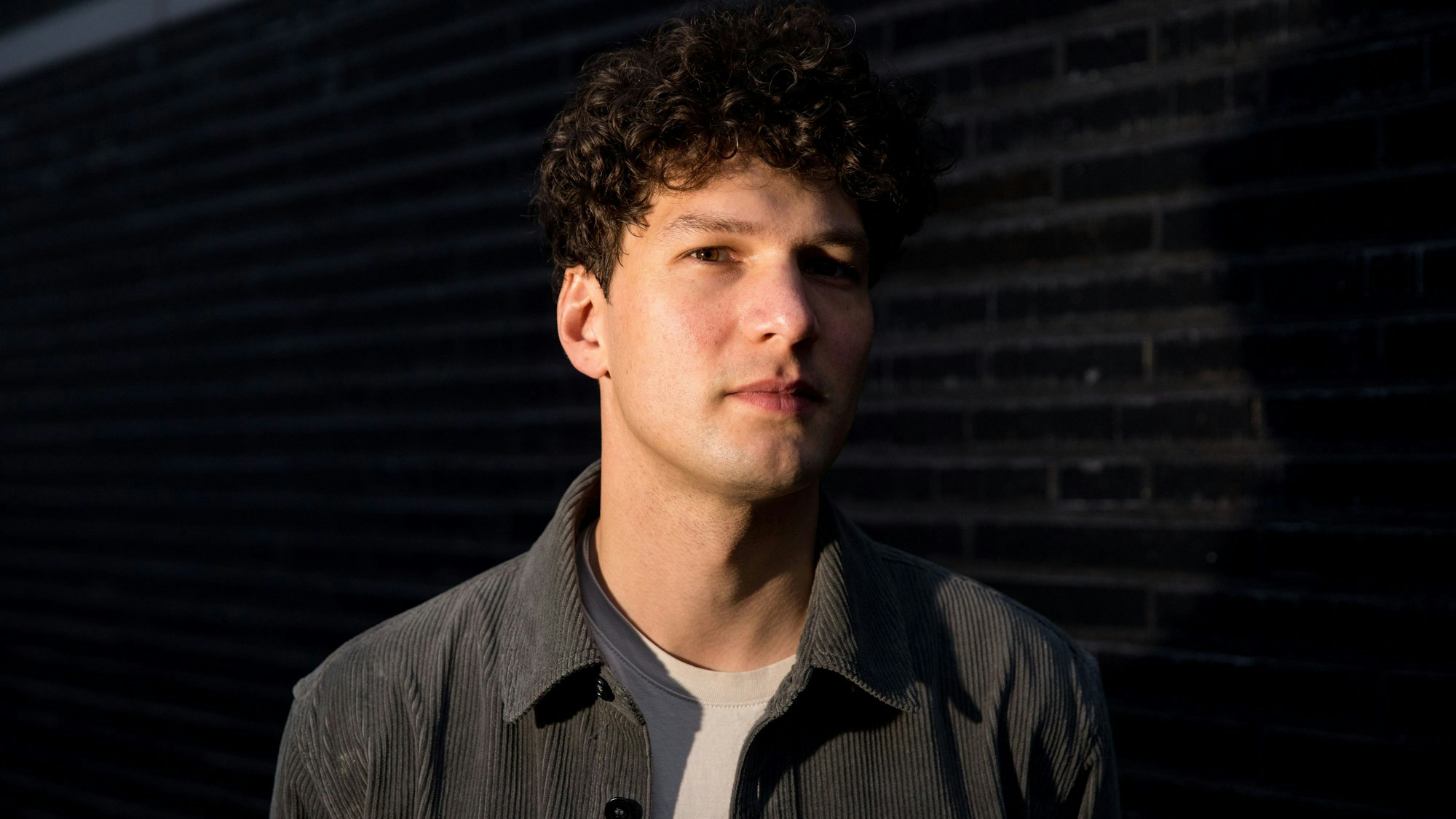 Fabian Mohn von der Band Neufundland vor einem dunklen Hintergrund