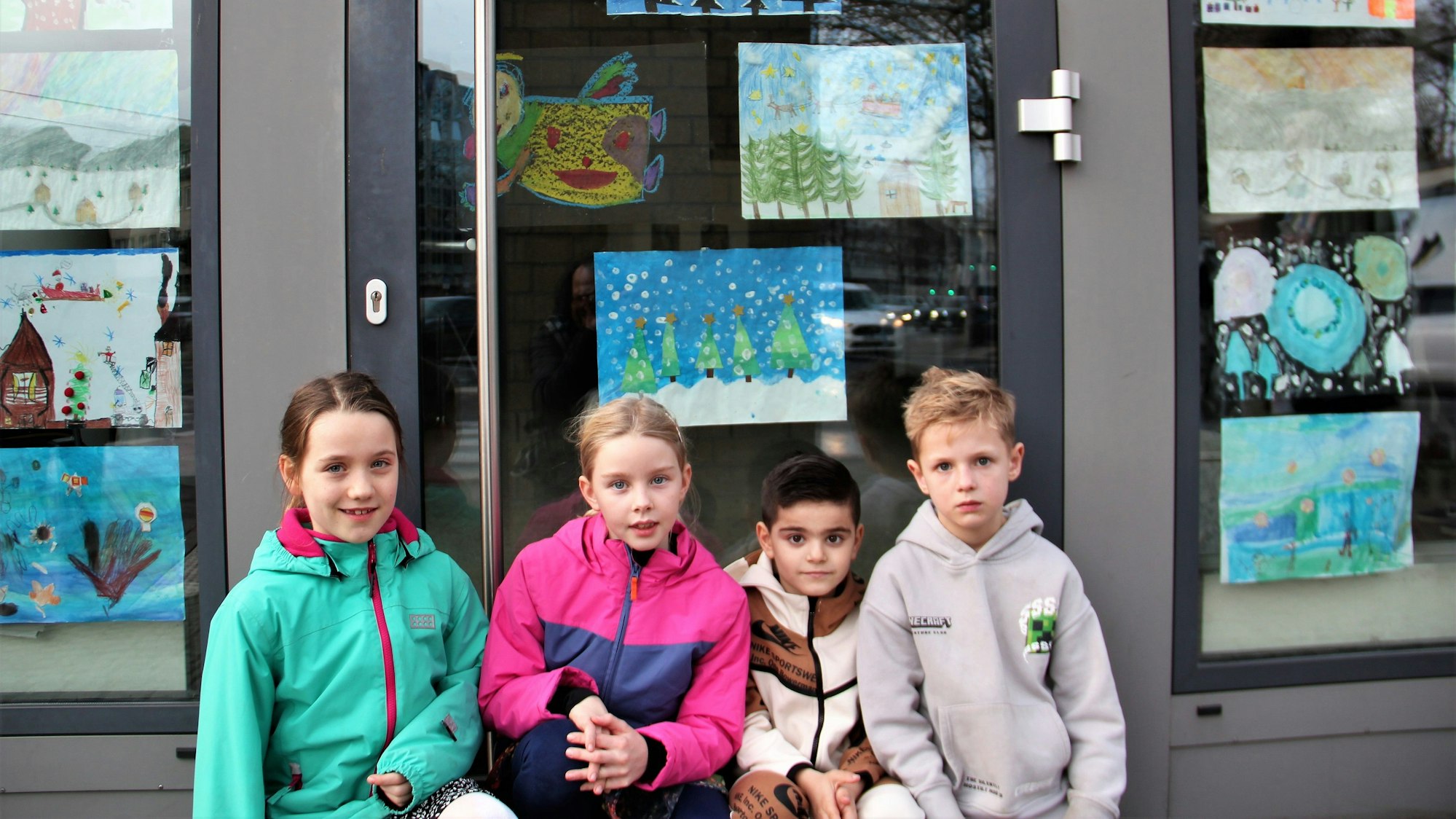 Pauline, Anna, Dilan und Thies stehen vor ihren Kunstwerken im Bezirksrathaus.