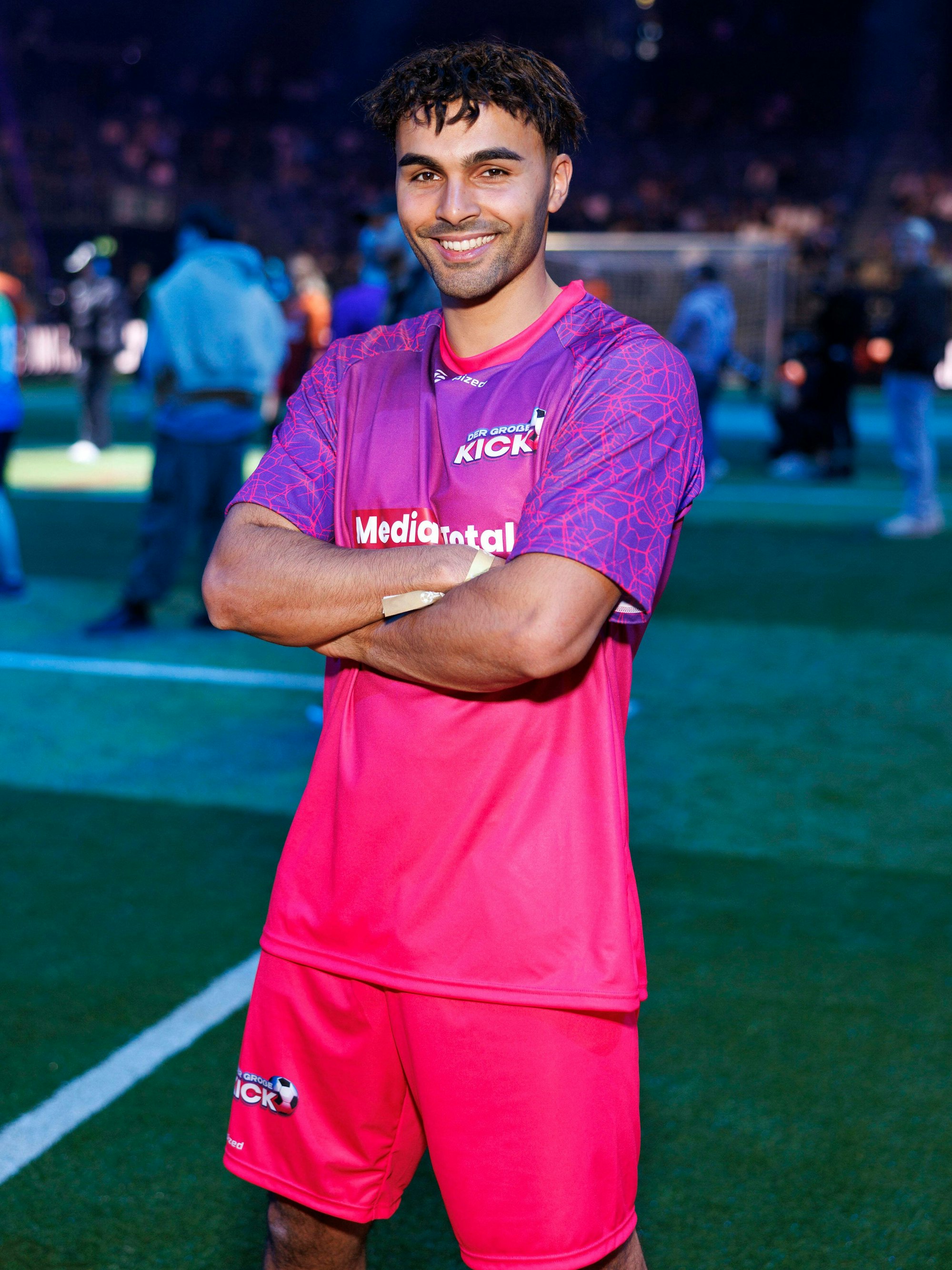 Younes Zarou steht im Trikot und mit verschränkten Armen auf dem Spielfeld.