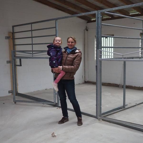 Das Bild zeigt Anne Spoo mit Tochter Paulina vor den Pferdeboxen.