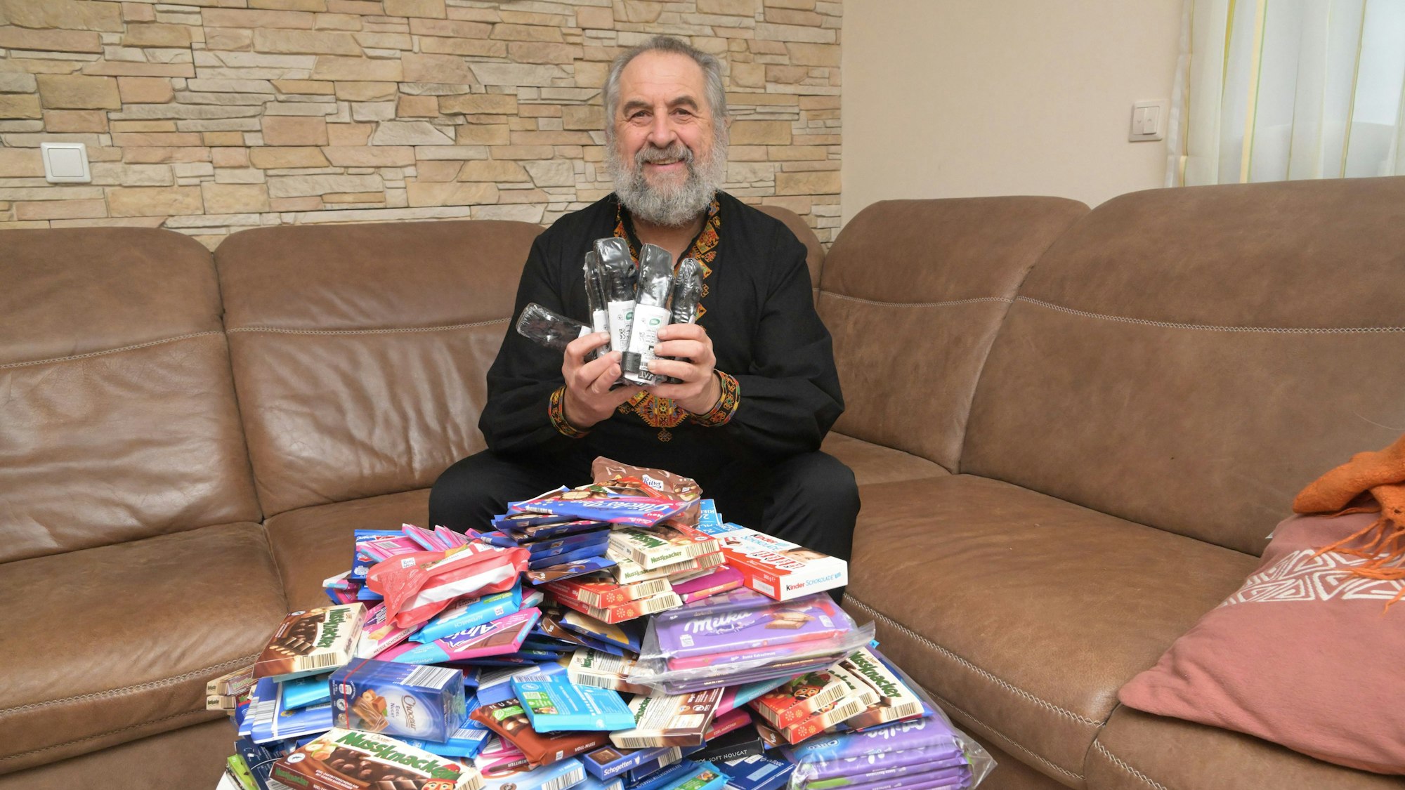 Paul Kruk sitzt auf seinem Sofa hinter einem Berg Süßigkeiten.