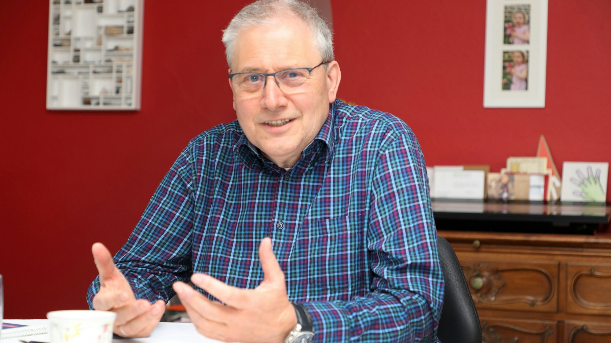 Wolfgang Weiden sitzt an einem Tisch und gestikuliert.