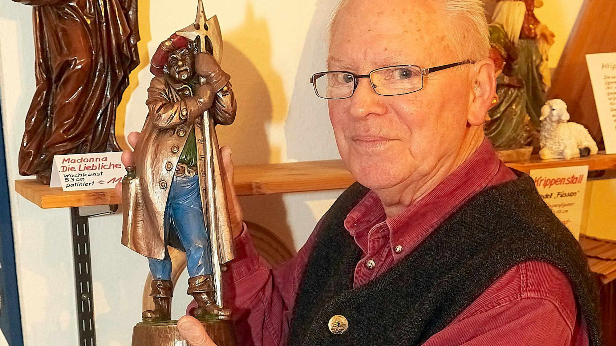 Wilhelm Spelter hält eine seiner Wachsfiguren in der Hand.