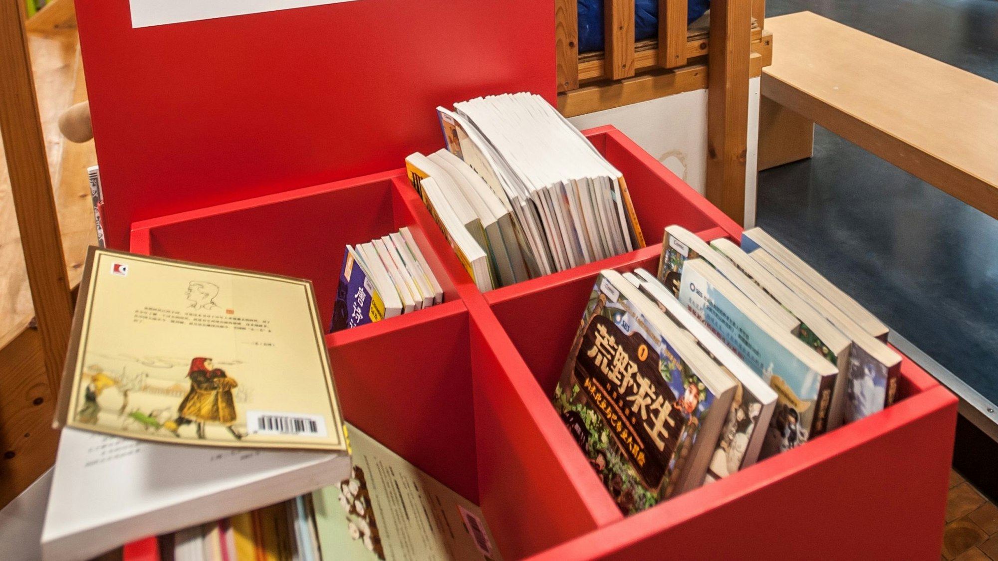 Bücherkisten in einer Lese-Ecke der Stadtbibliothek Leverkusen mit chinesischen Kinderbüchern