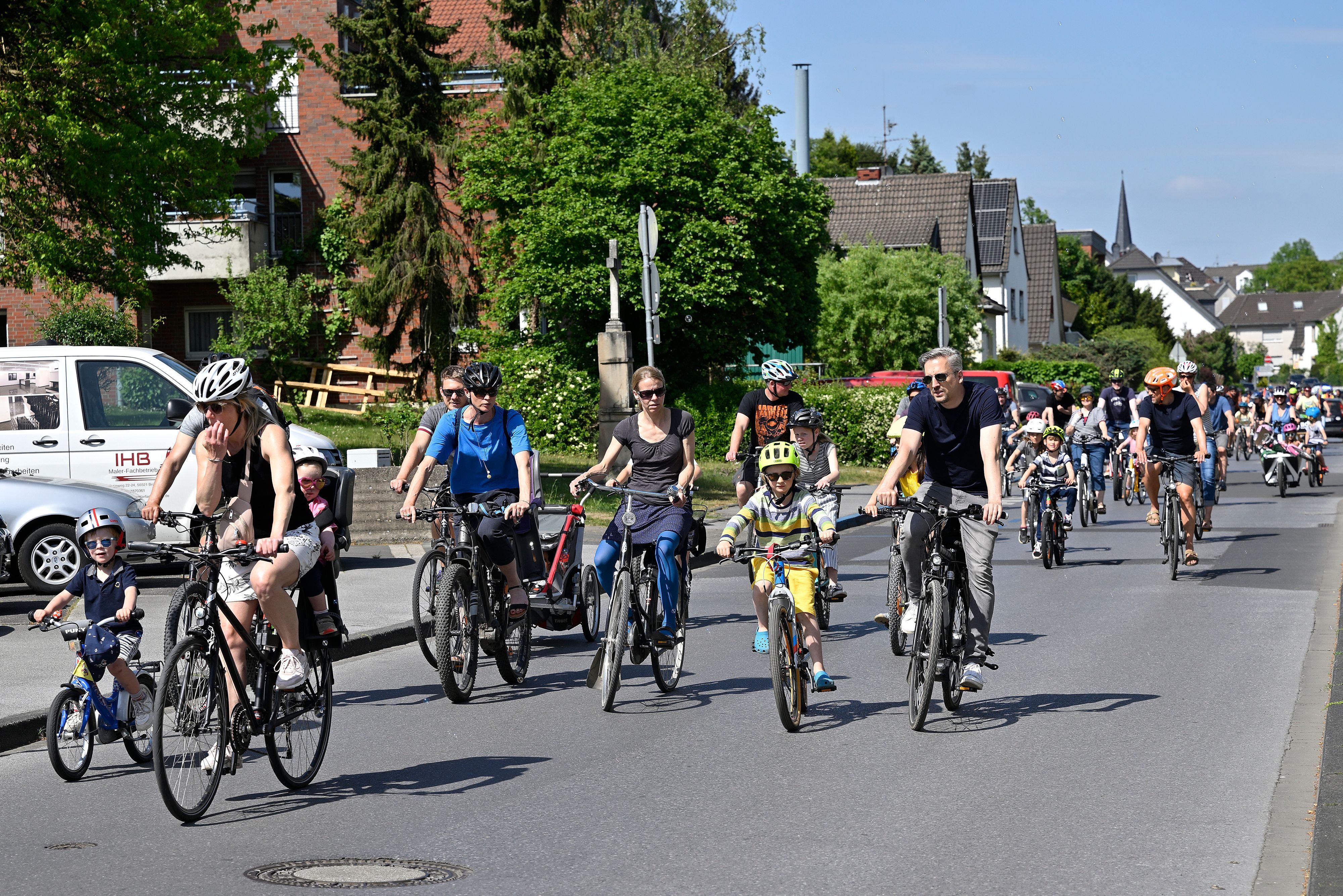 Erwachsene und Kinder fahren für die Demo Kodical Mass Fahrrad auf den Rösrather Straßen.