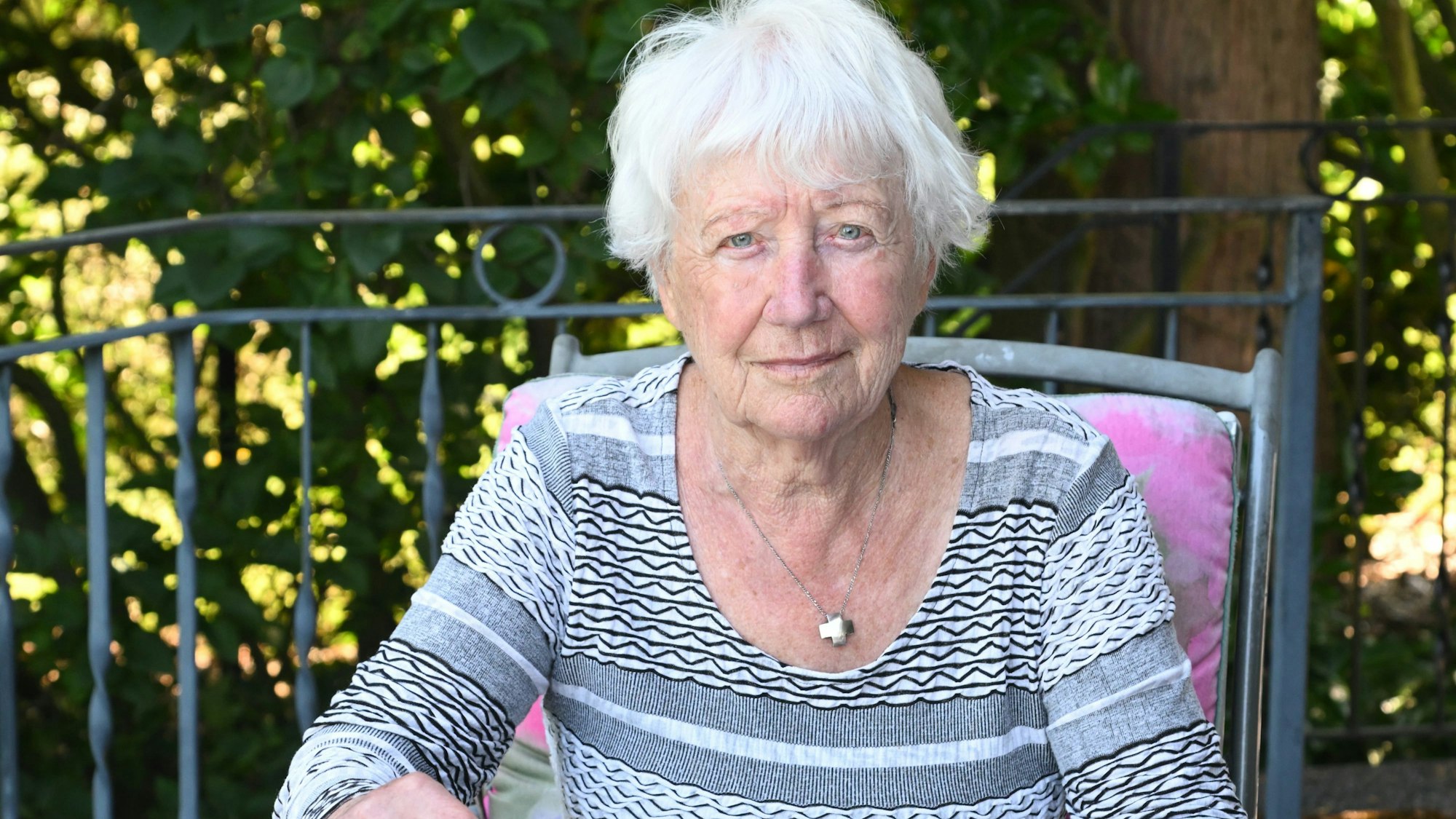 Margot Bäumerich sitzt an ihrem Gartentisch.