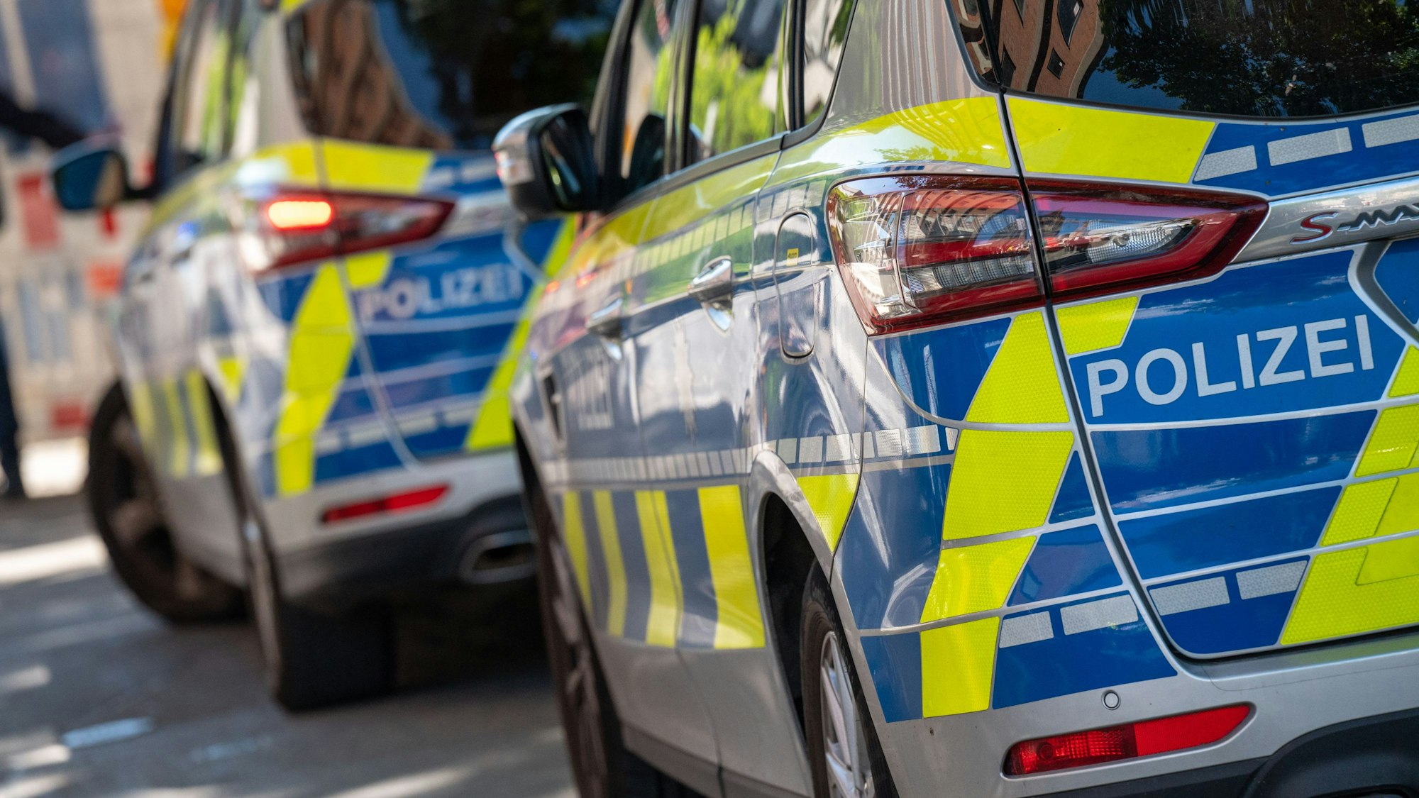 Zwei Polizeiautos stehen auf einer Straße hintereinander.