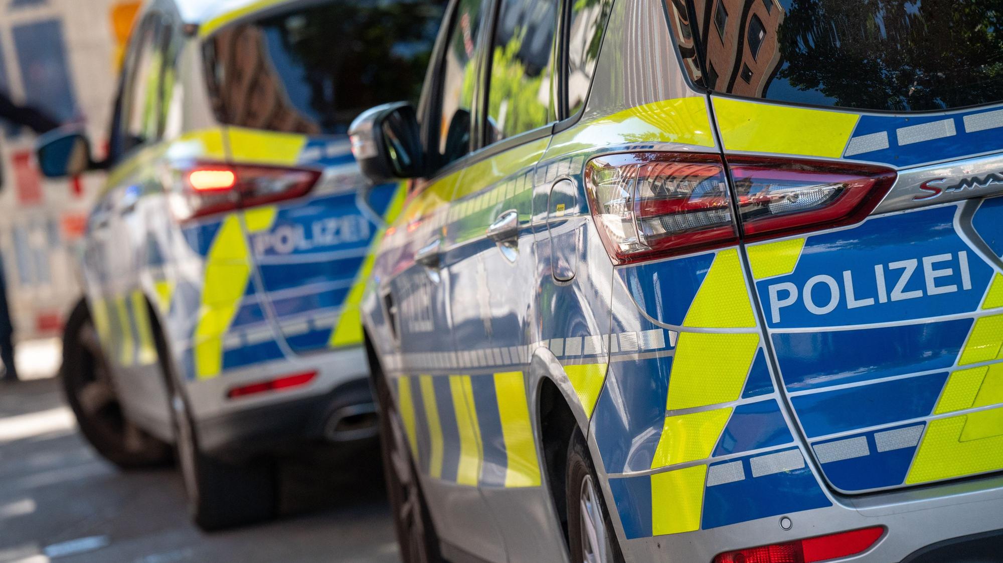 Polizeiwagen stehen in einer Straße.