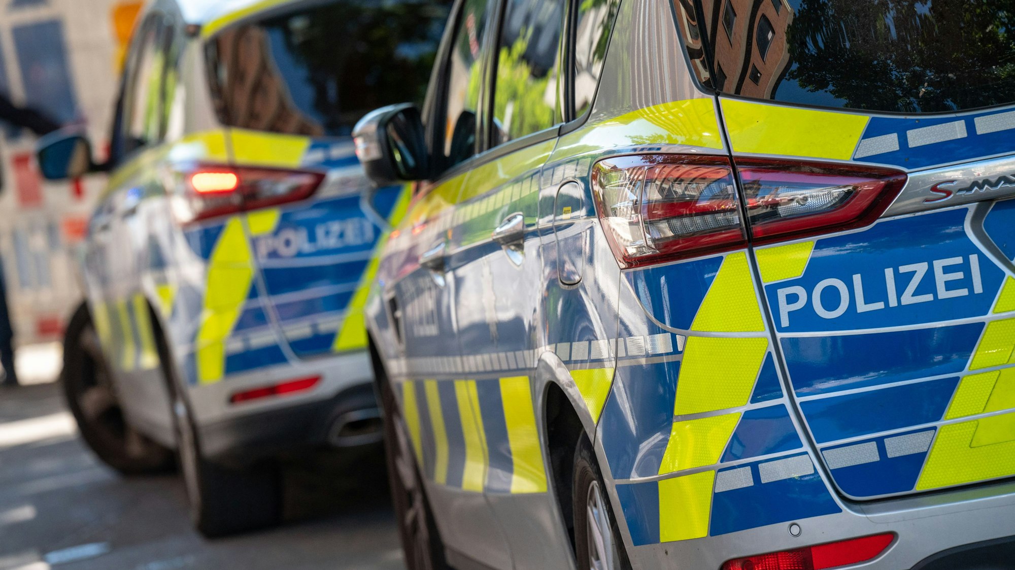 Polizeiwagen stehen in einer Straße.