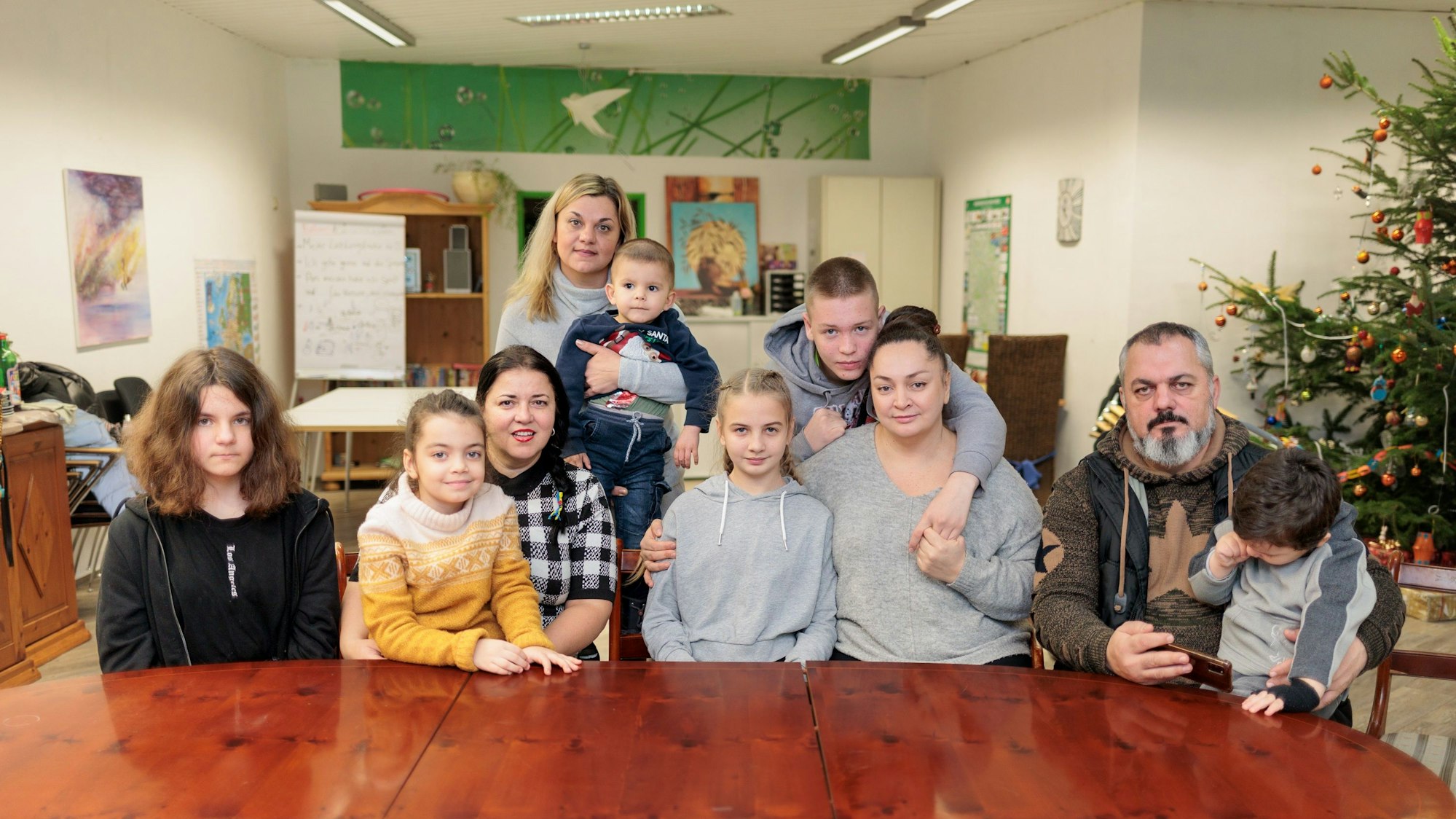 Zwei geflüchtete Familien aus der Ukraine sitzen an einem großen Tisch im Zentrum des Caritas-Verbandes in Gummersbach.