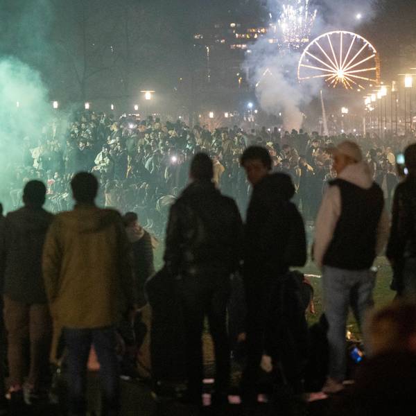 Menschen stehen zusammen an Silvester und zünden Feuerwerkskörper