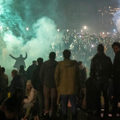 Menschen stehen zusammen an Silvester und zünden Feuerwerkskörper