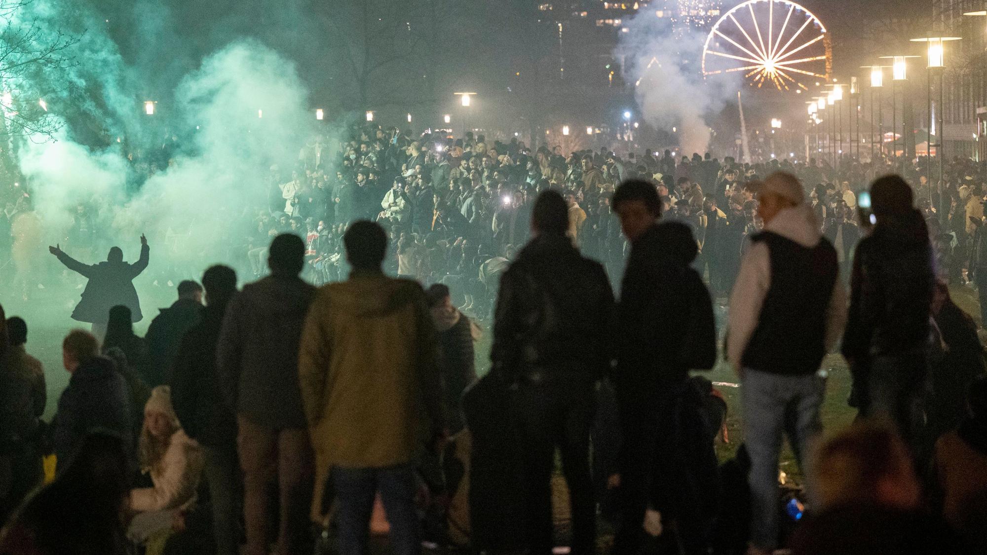 Menschen stehen zusammen an Silvester und zünden Feuerwerkskörper