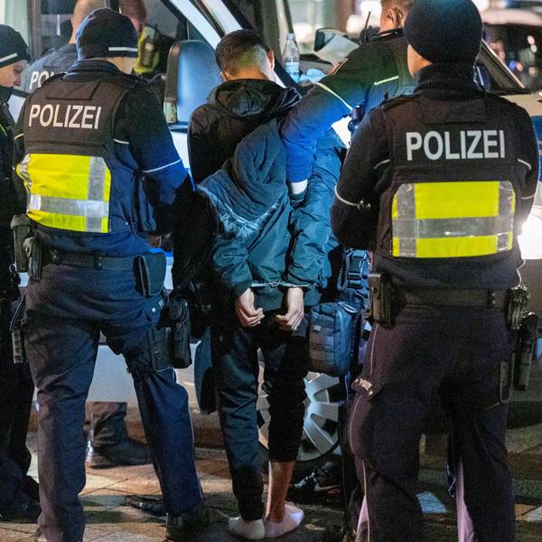 Polizeibeamte halten einen Häftling in Handschellen