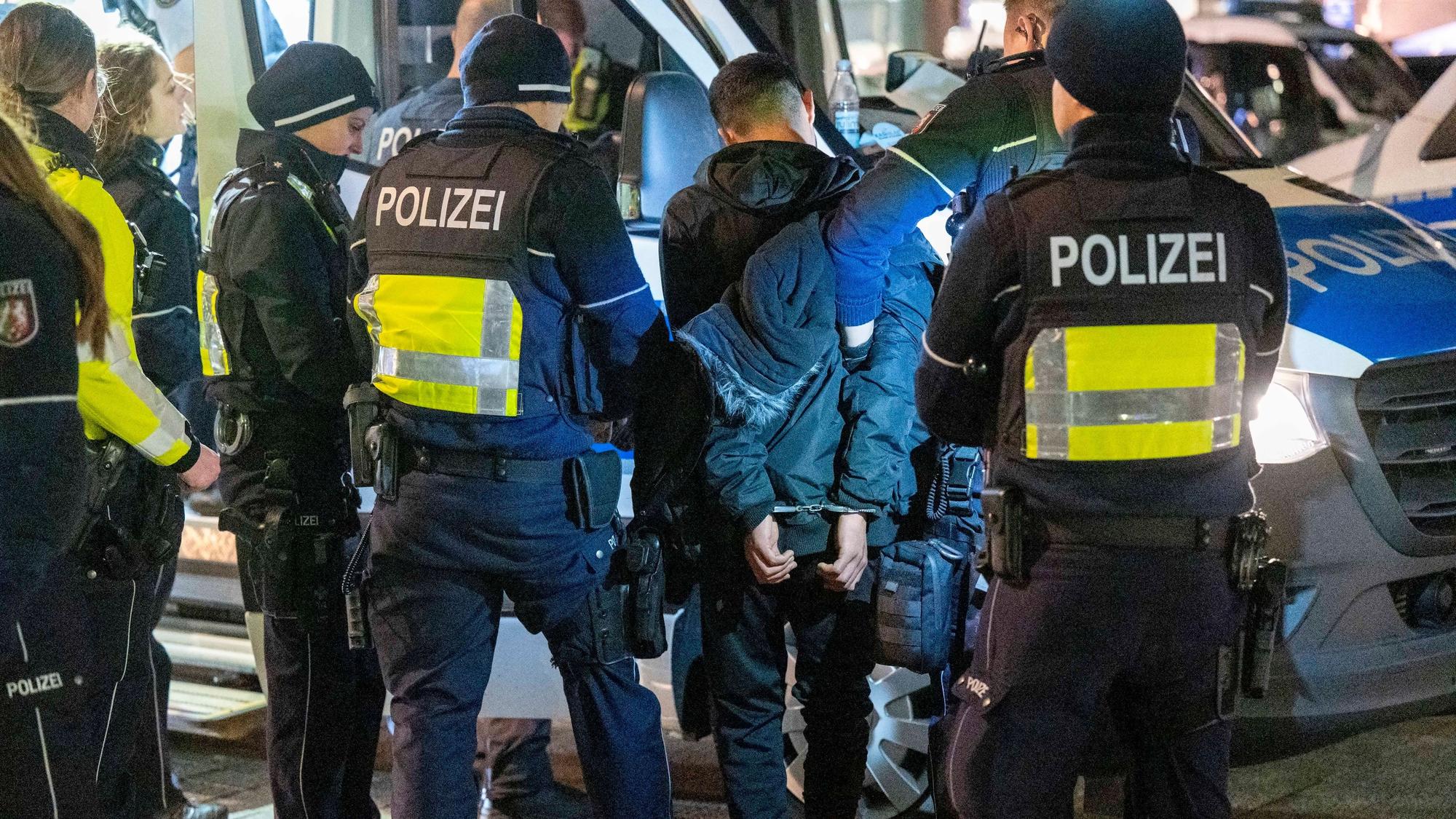 Polizeibeamte halten einen Häftling in Handschellen